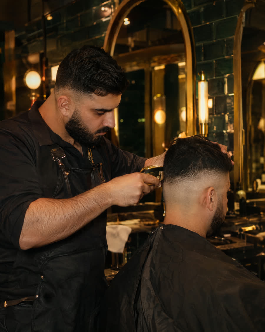 Barber finishing a fade in a Dubai barbershop